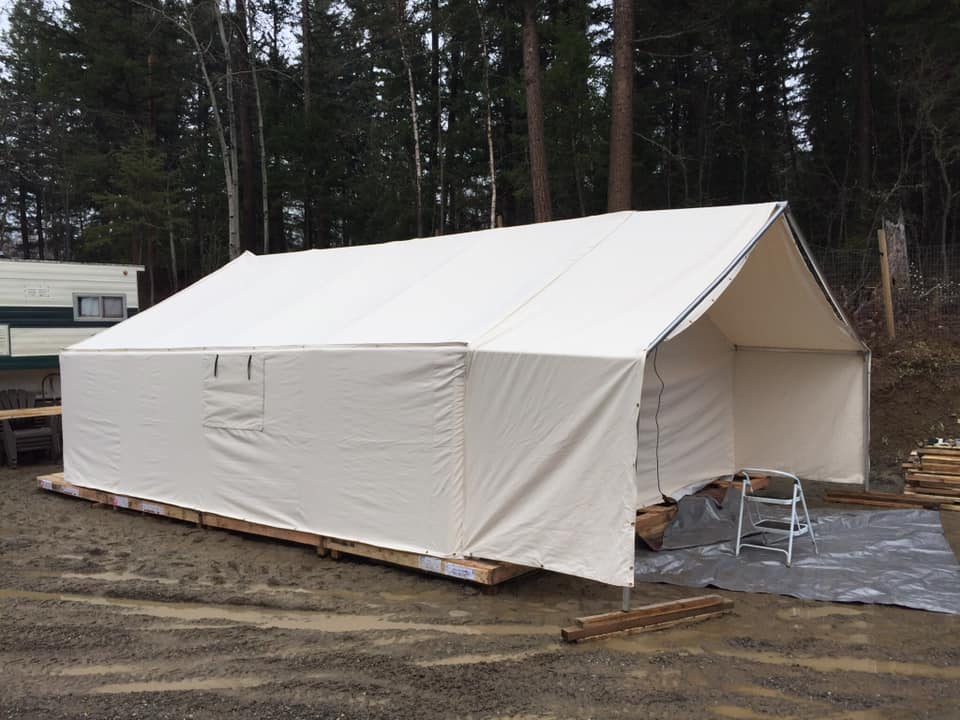 A large white tent is sitting on top of a wooden pallet