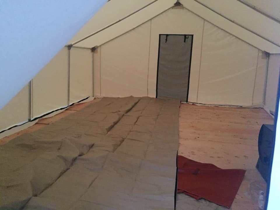 The inside of a tent with a blanket on the floor