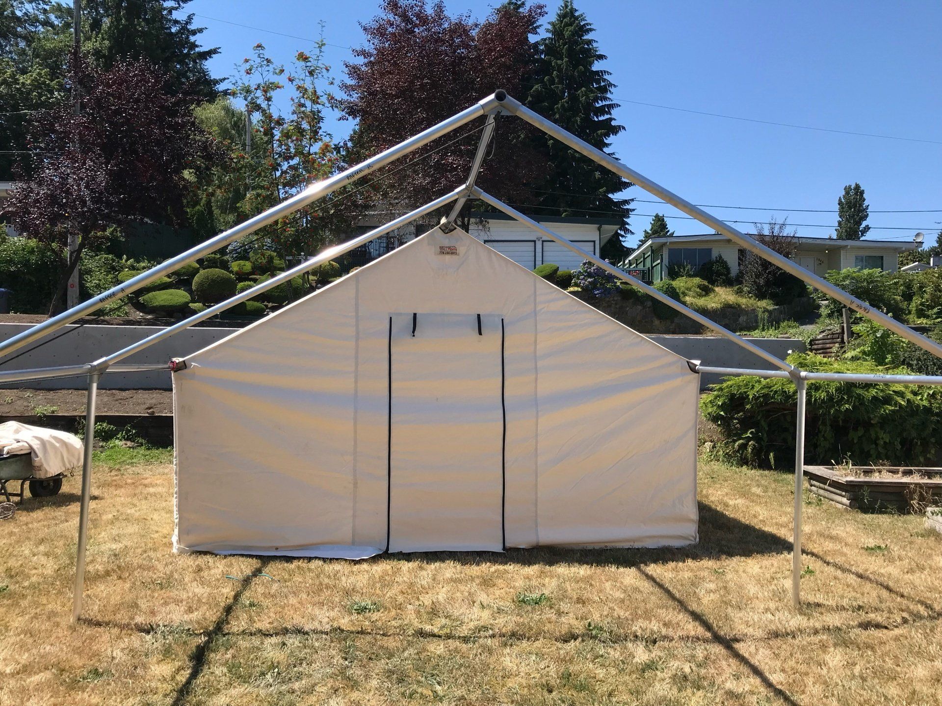 A large white tent is sitting in the middle of a grassy field.