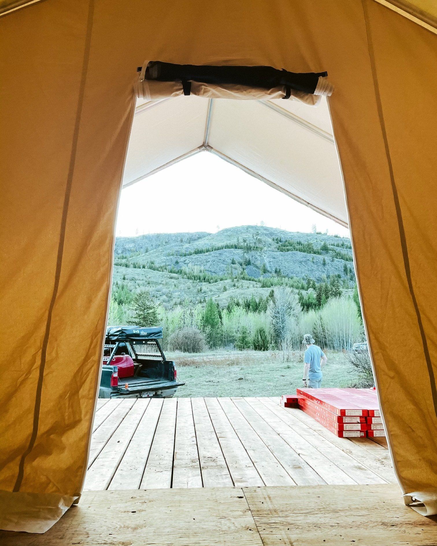 A tent with a view of a valley and mountains