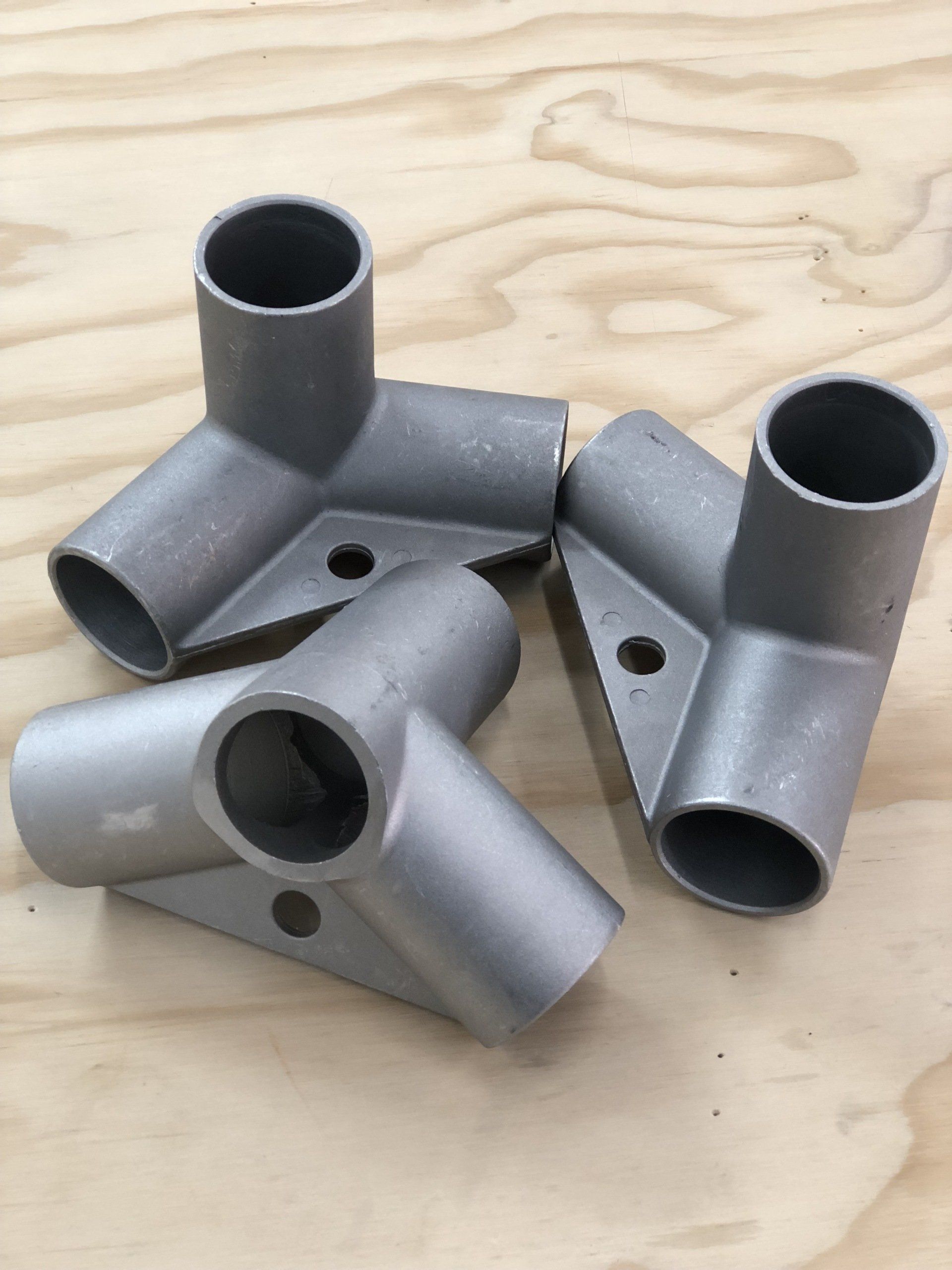 A bunch of metal pipes are sitting on a wooden table