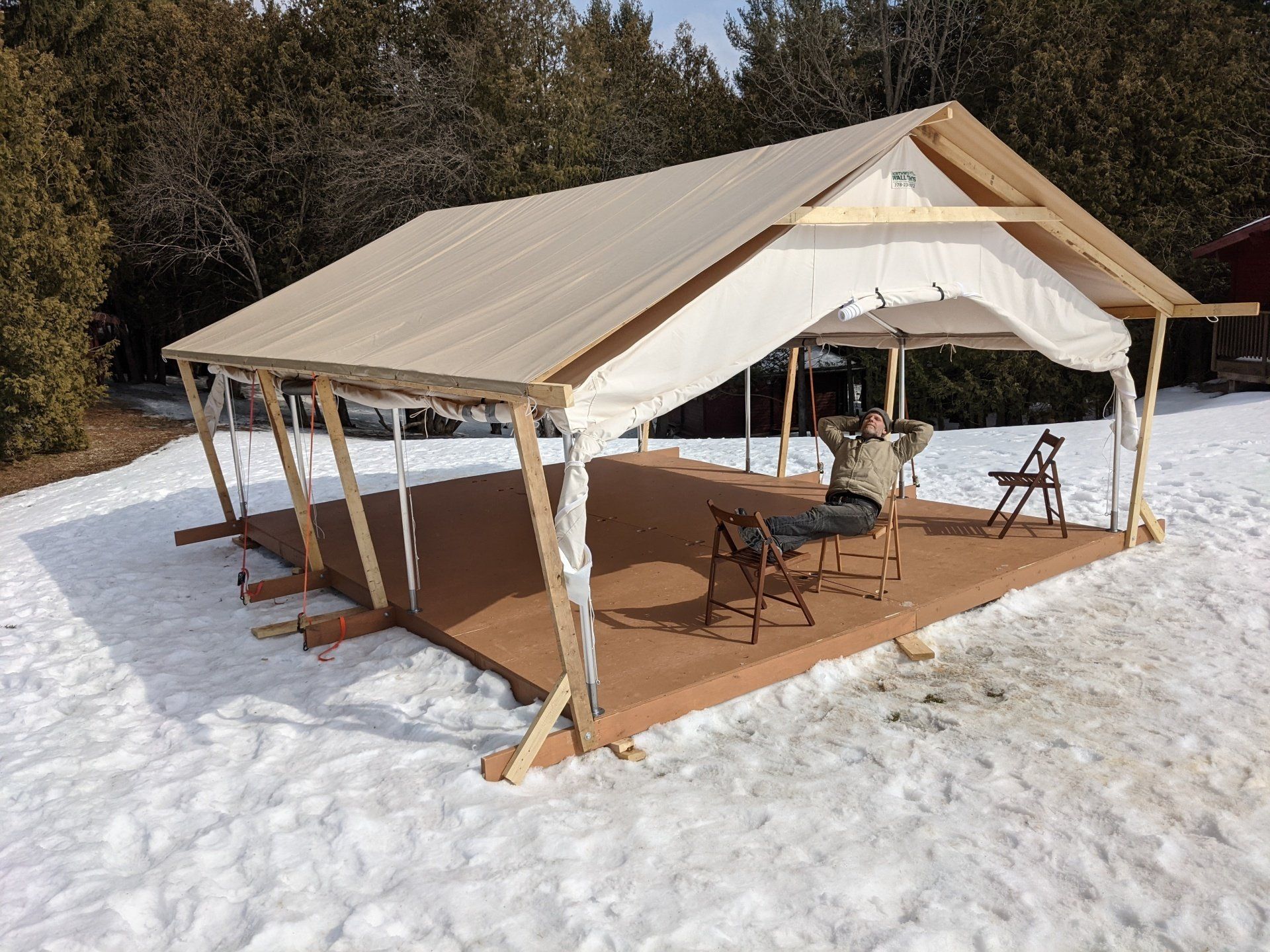 A tent is sitting in the middle of a snowy field.
