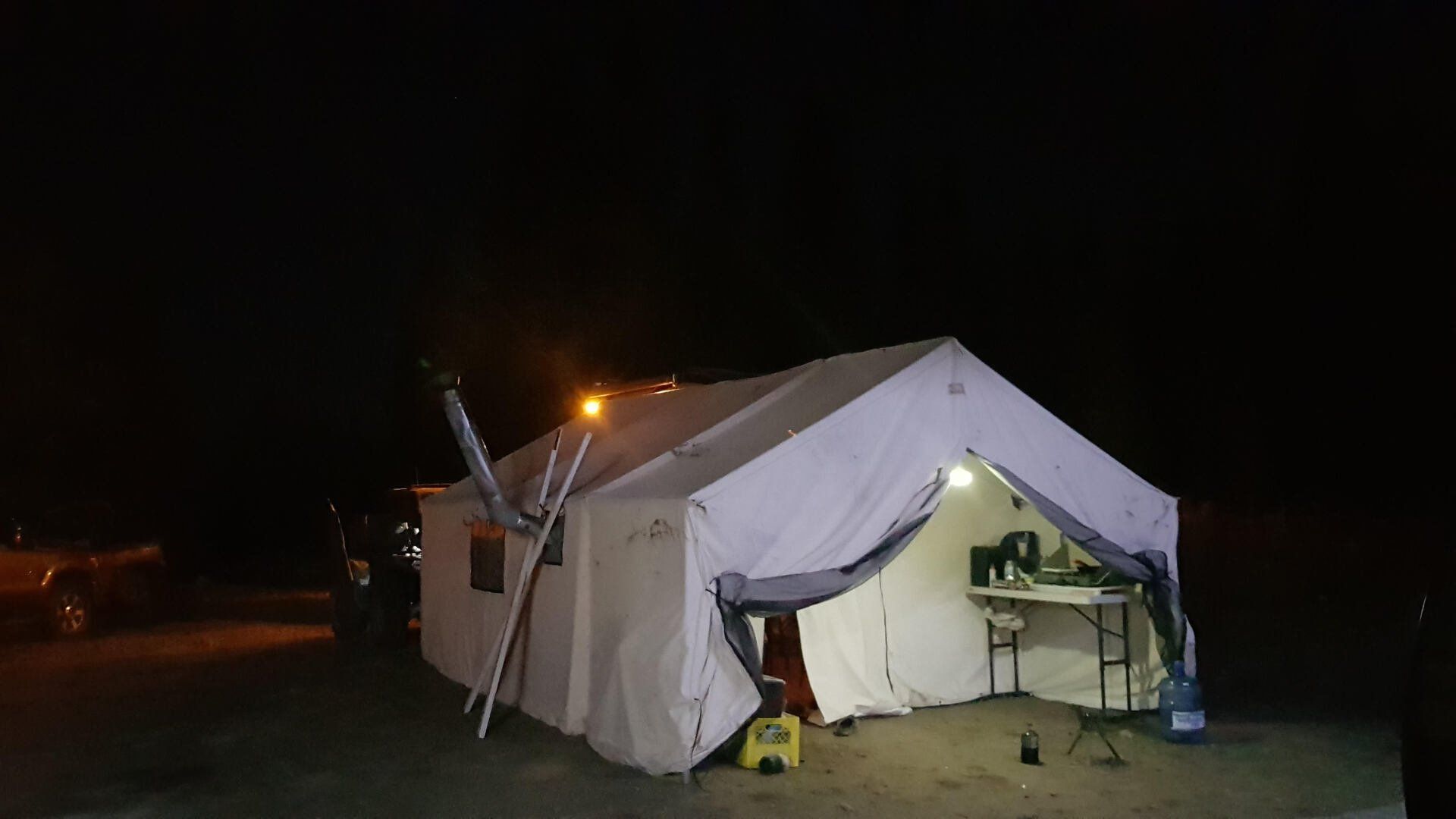 A large white tent is lit up at night