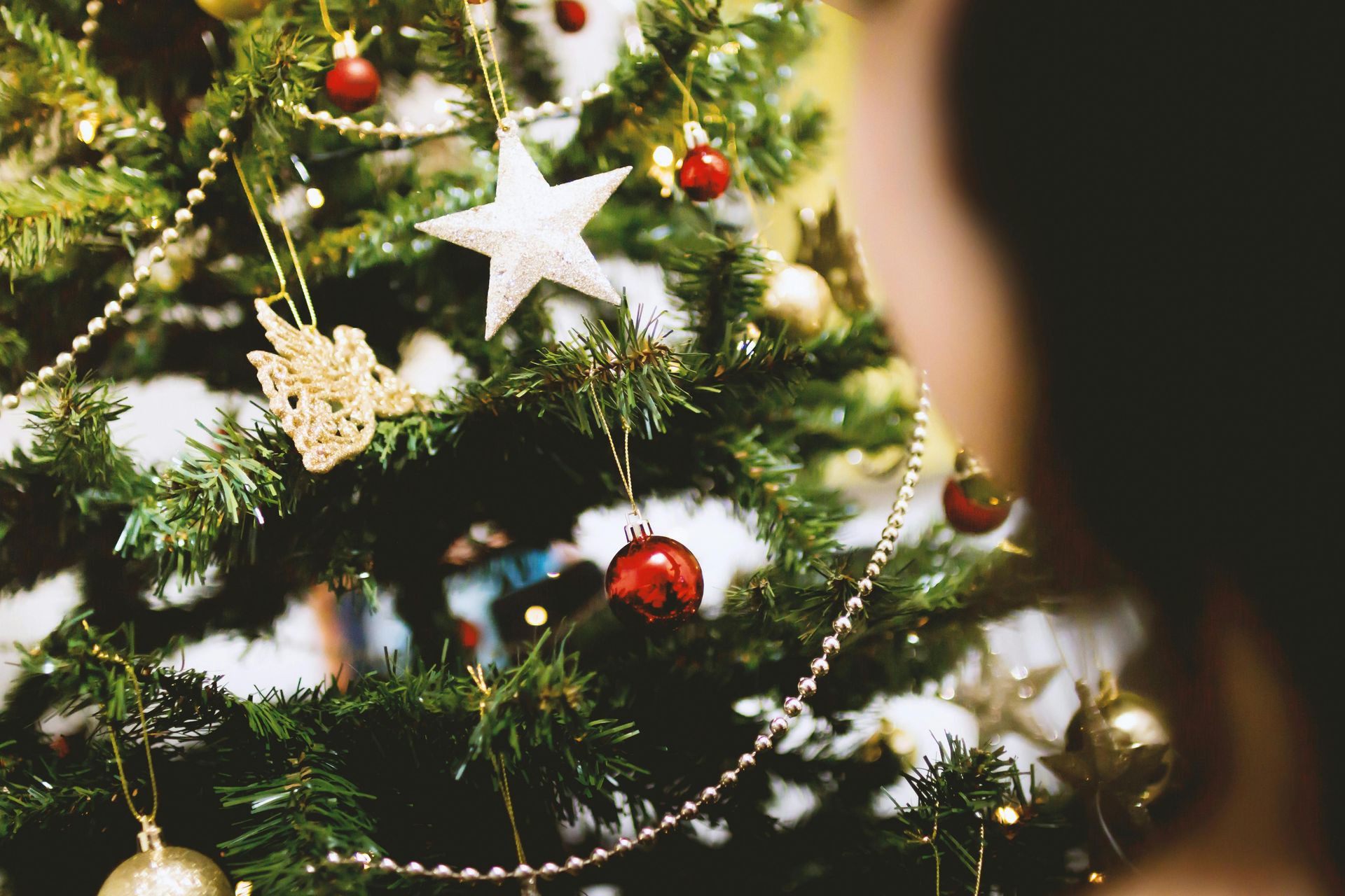 A close up of a christmas tree with decorations hanging from it.