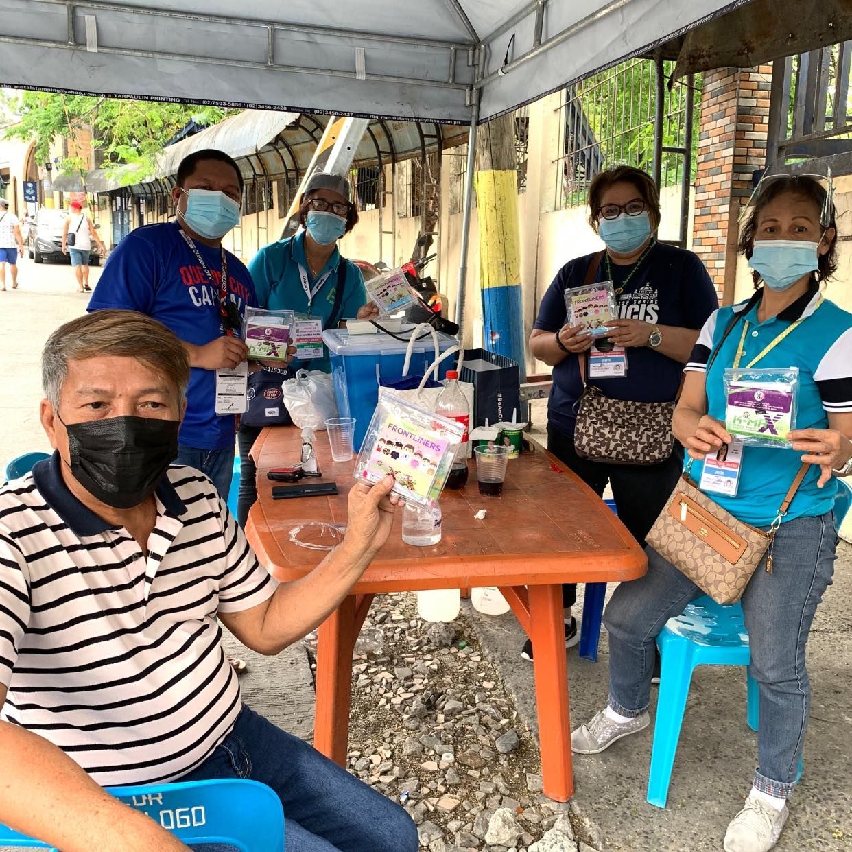 A group of people wearing face masks are sitting around a table.