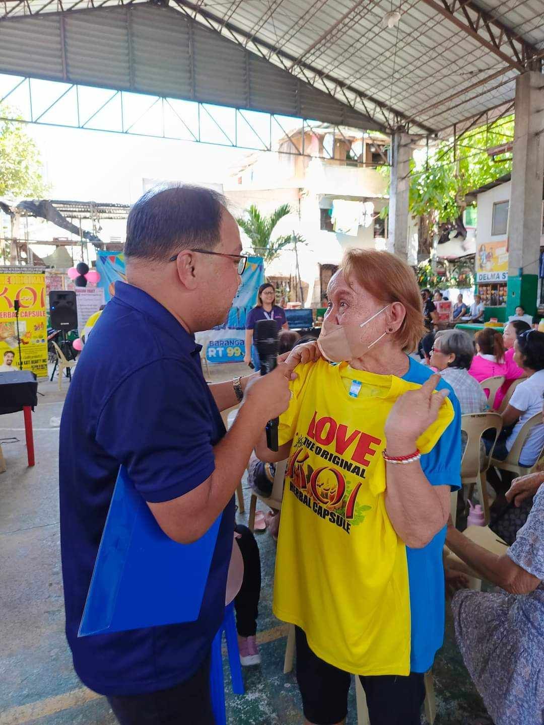 A man is giving a woman a yellow shirt that says love