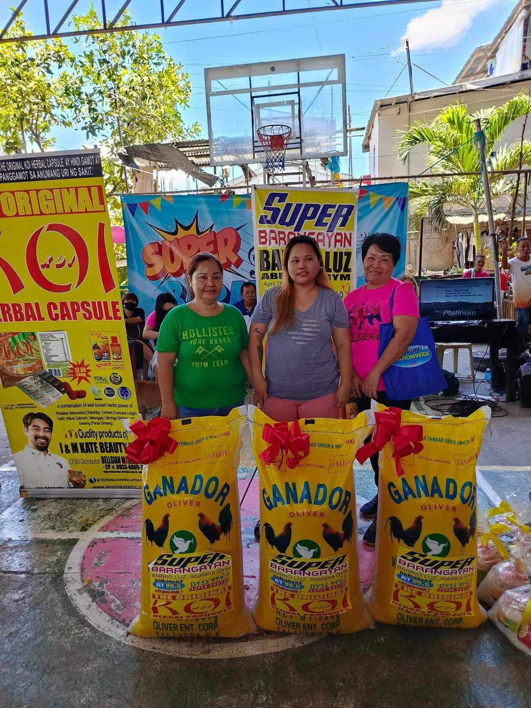Three women are standing next to each other holding bags of food.