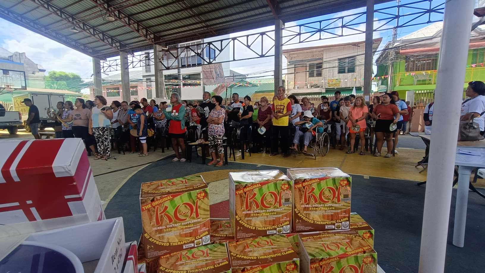 A large group of people are standing under a roof.