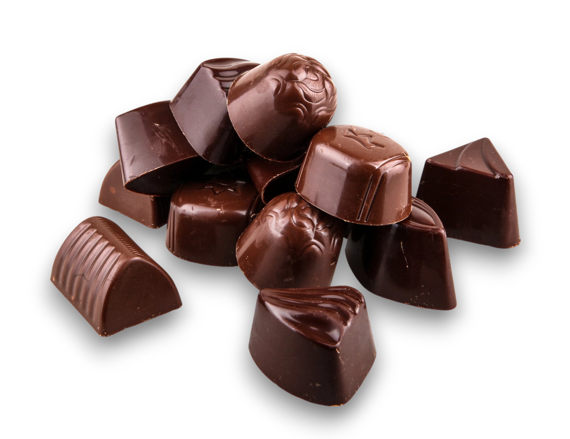 Un mucchio di cioccolatini fondenti assortiti di varie forme e motivi su uno sfondo bianco.