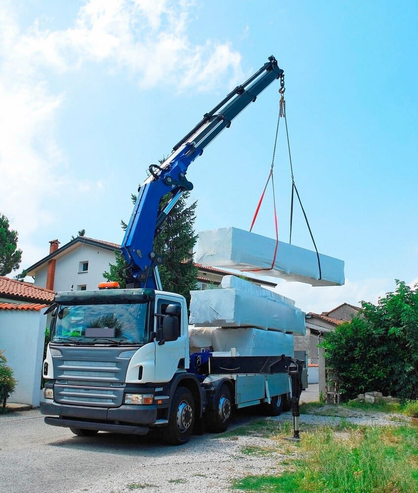 A Truck With a Crane Attached to It is Carrying a Stack of Blocks — Smithys Crane Hire in Brinsmead, QLD
