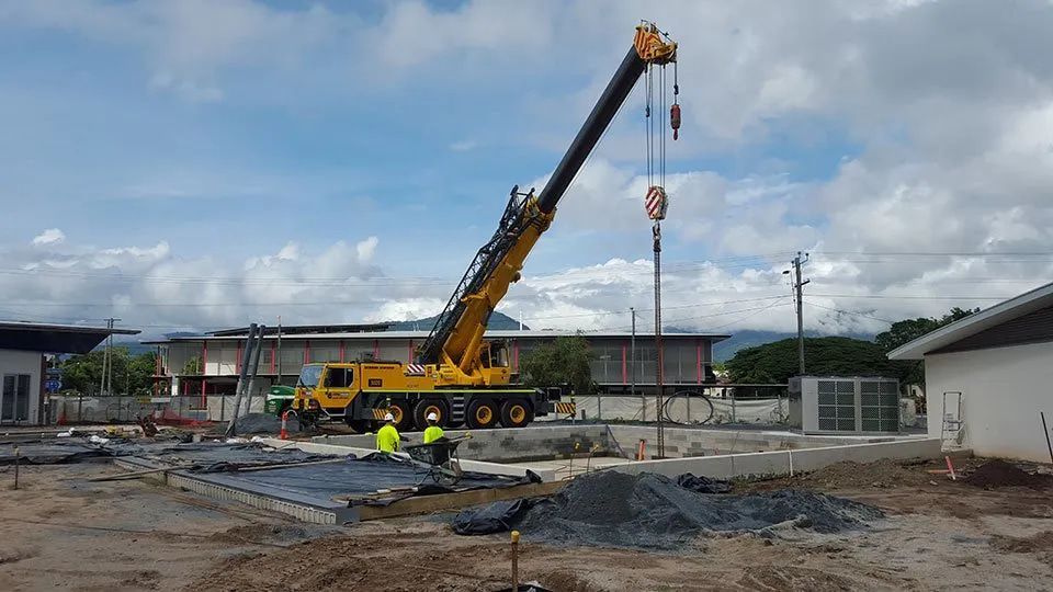 A Large Yellow Crane In A Construction Site — Smithys Crane Hire in Trinity Beach, QLD