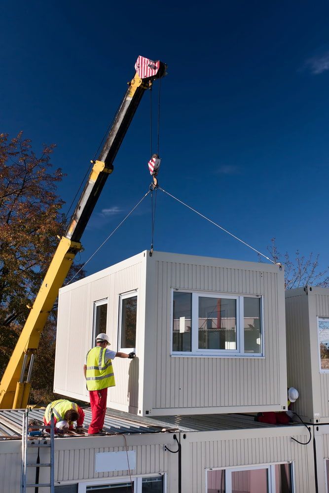 A Crane is Lifting a Container on Top of a Building — Smithys Crane Hire in Innisfail, QLD