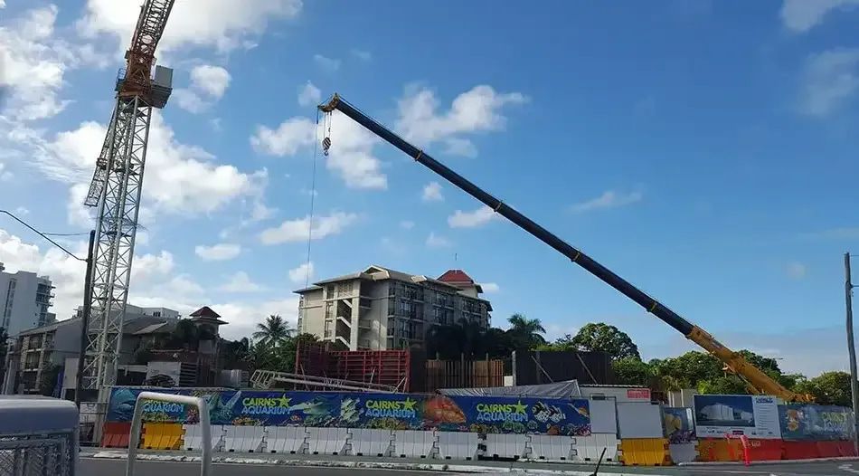 A Construction Site With a Crane in the Foreground and a Building in the Background — Smithys Crane Hire in Edmonton, QLD