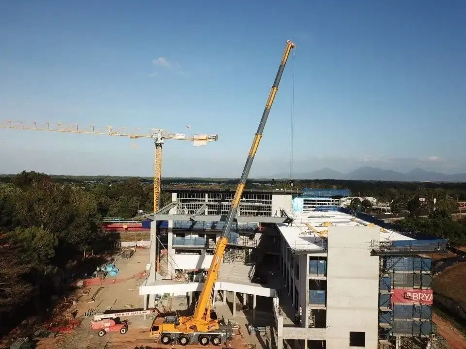 An Aerial View of a Large Building Under Construction With a Crane — Smithys Crane Hire in Redlynch, QLD
