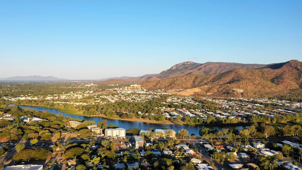 An Aerial View of a City Surrounded by Mountains and a River — Smithys Crane Hire in Port Douglas, QLD