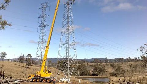 Large Yellow Crane Working On A Power Tower — Smithys Crane Hire in Trinity Beach, QLD