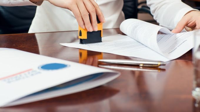 A person is stamping a piece of paper on a table.