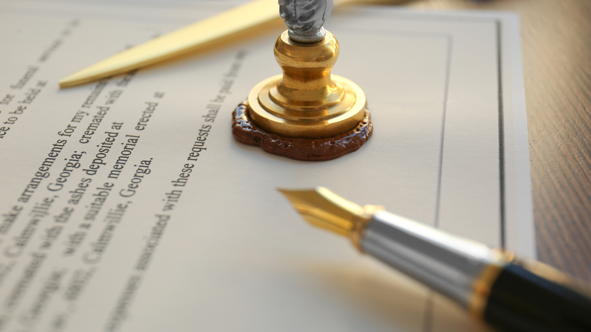 A fountain pen is sitting on top of a piece of paper next to a wax seal.