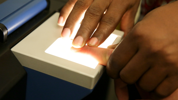 A person 's finger is being scanned by a machine