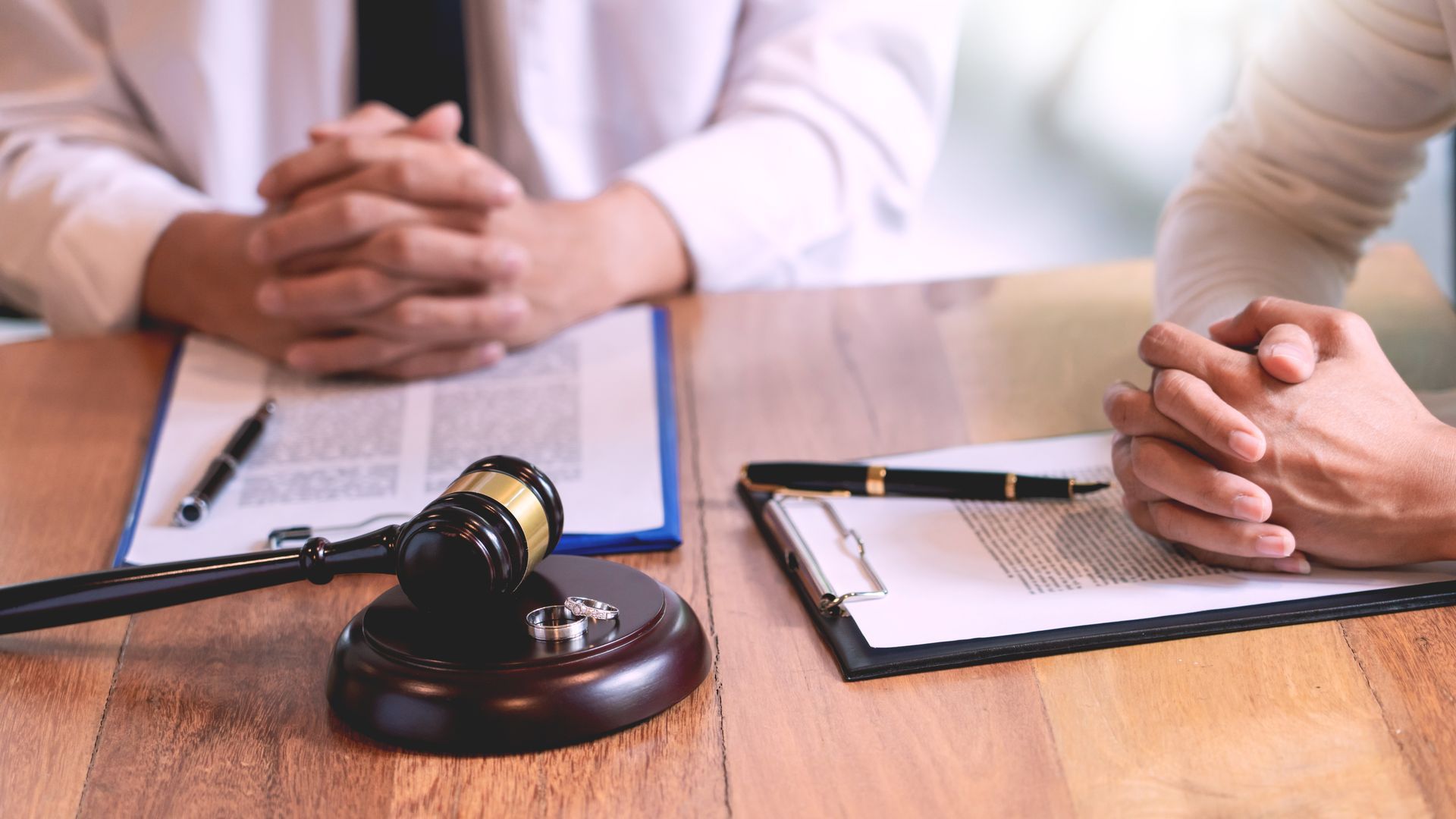 A man and a woman are sitting at a table with papers and a judge 's gavel.