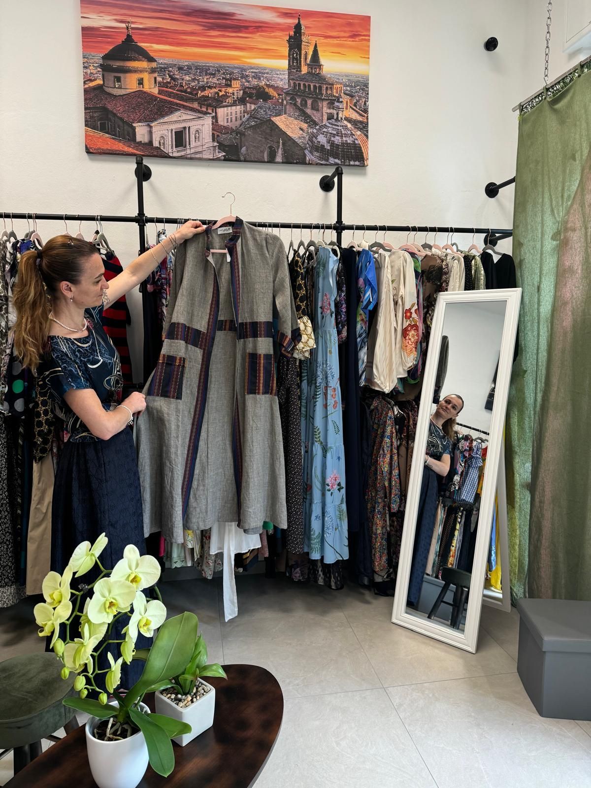 Una donna guarda un vestito in un negozio.