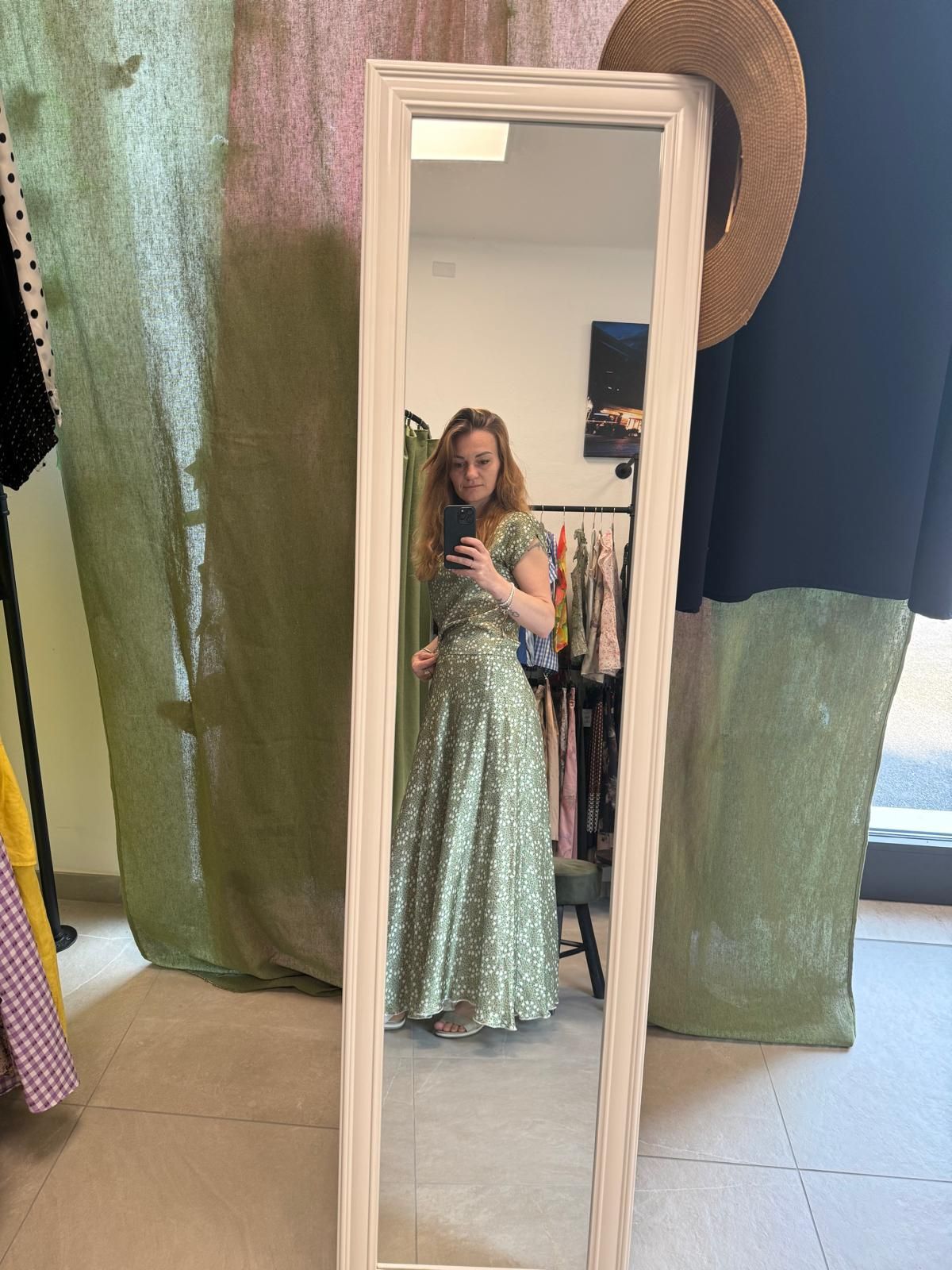 Una donna sta scattando una foto di se stessa in uno specchio a figura intera.