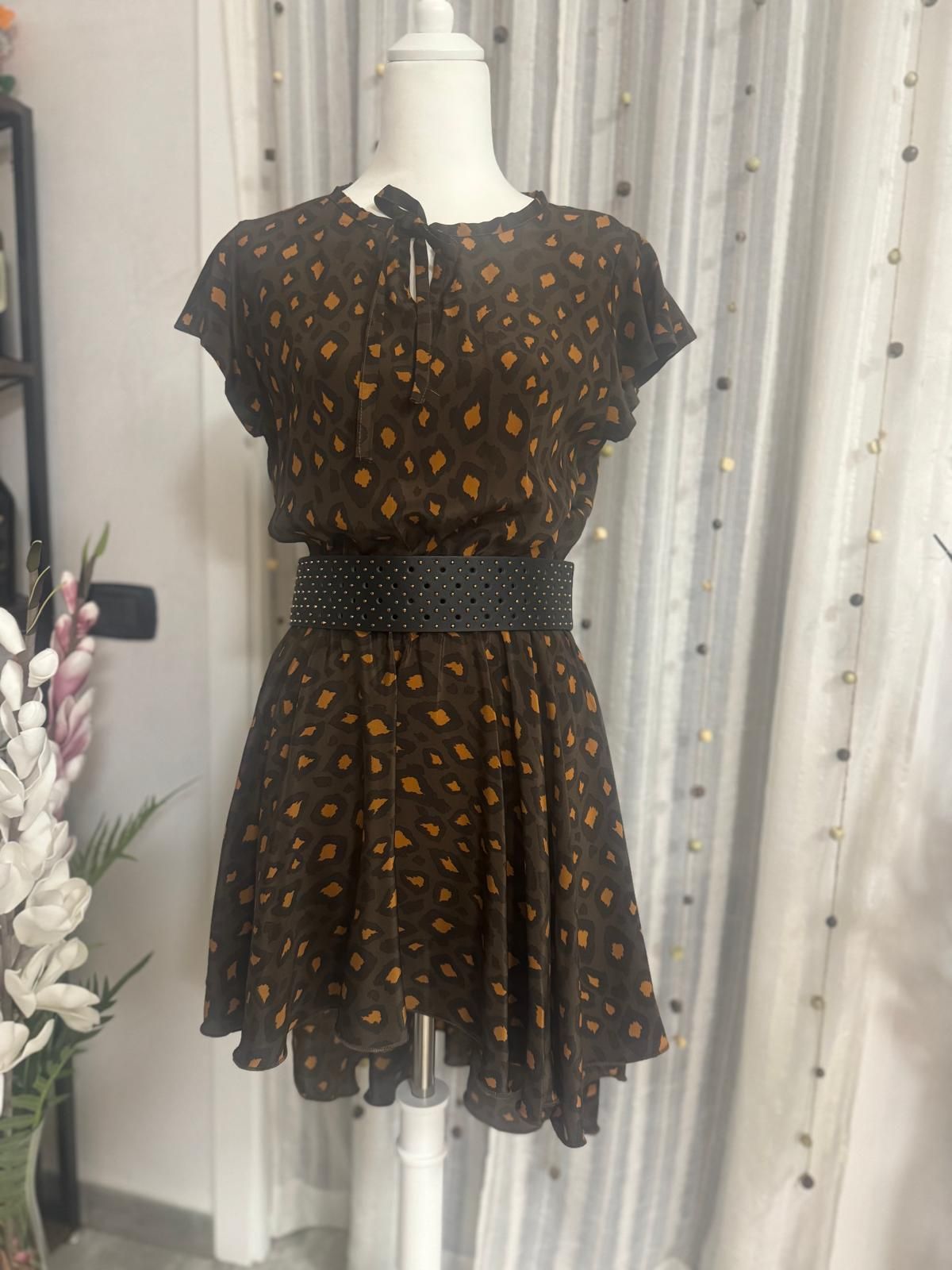 Un vestito marrone con pois gialli è su un manichino.