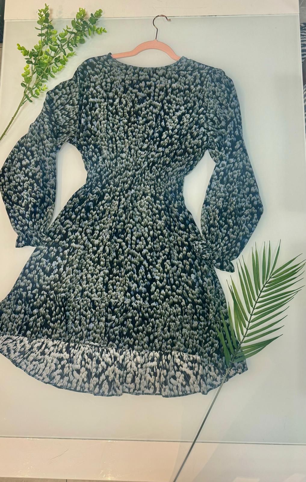 Un vestito bianco e nero è appeso a una gruccia rosa