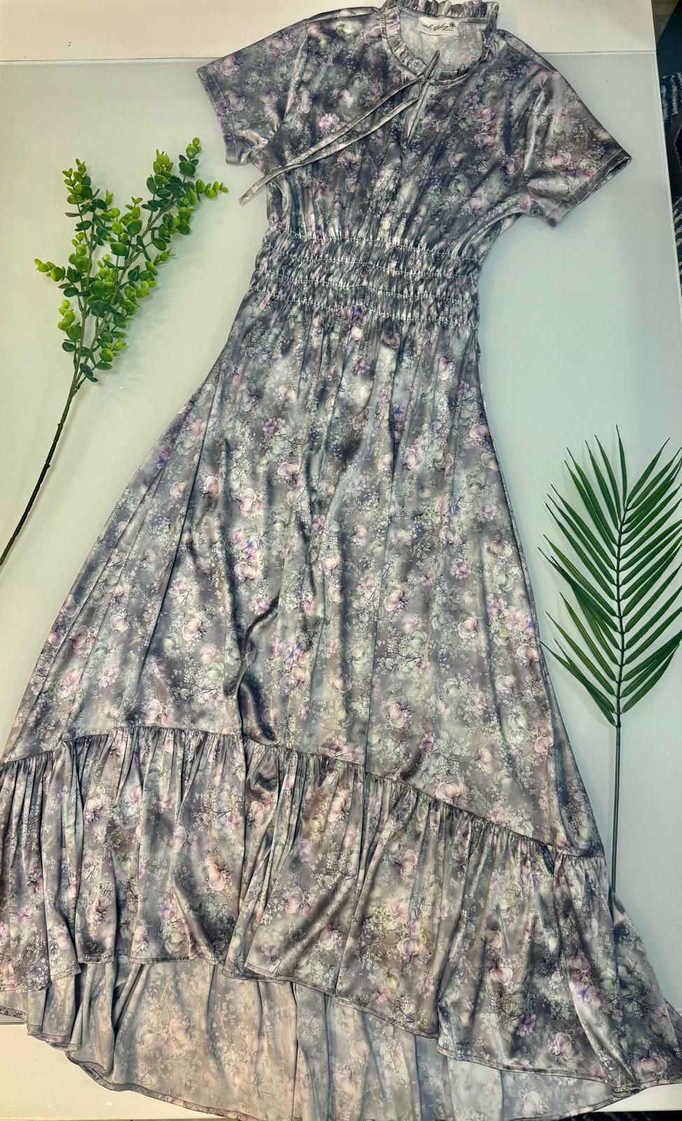 Un vestito grigio è seduto su un tavolo accanto a una pianta.