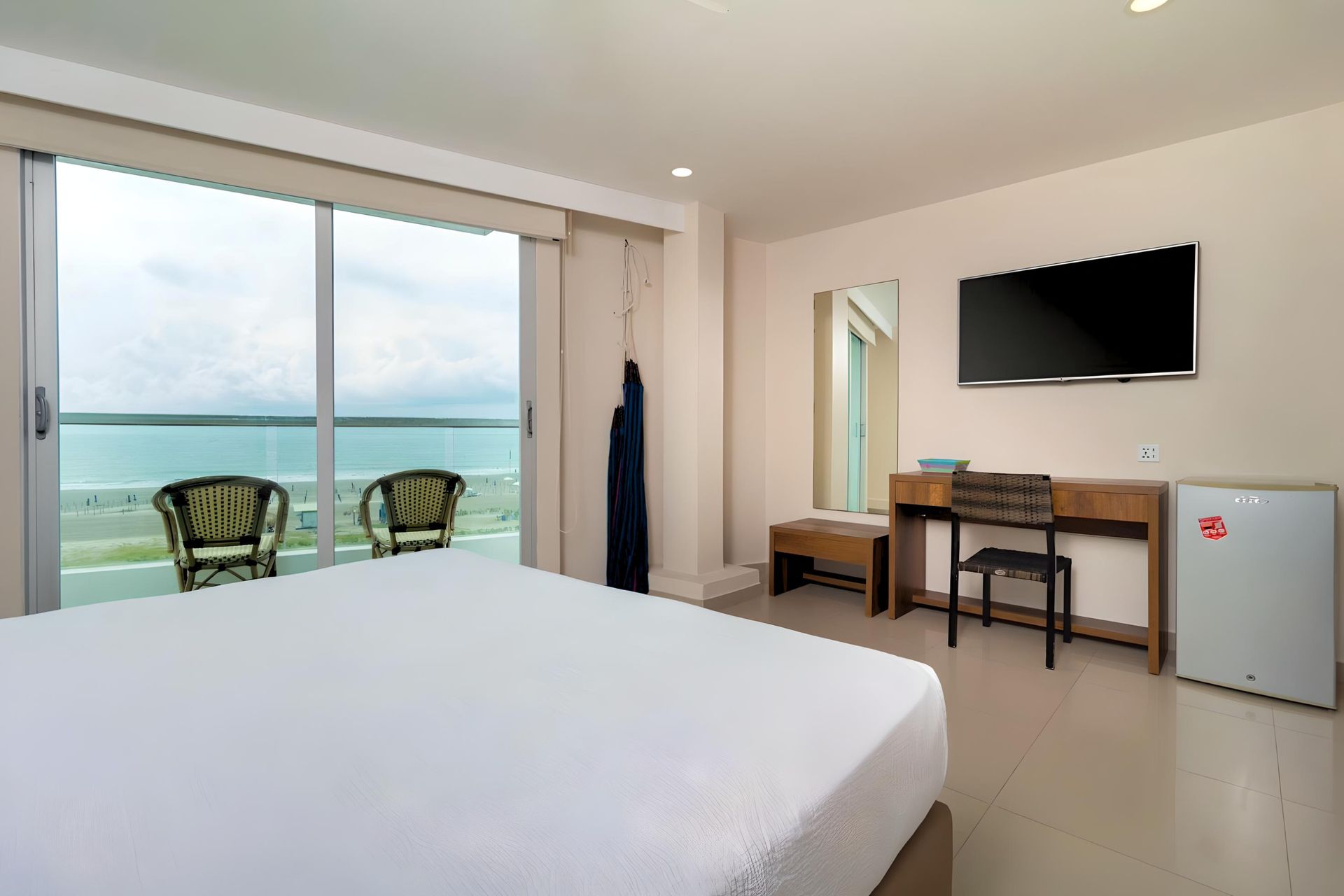 Una habitación de hotel con una cama grande y un televisor de pantalla plana.