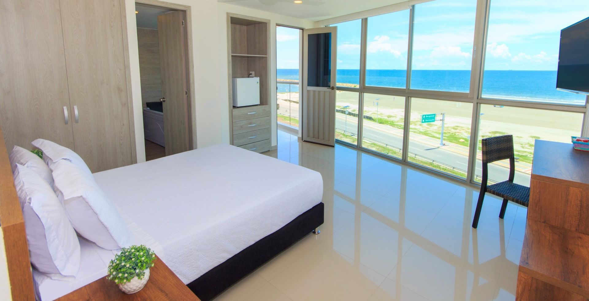 Hay una cama grande en el medio de la habitación con vista al océano.