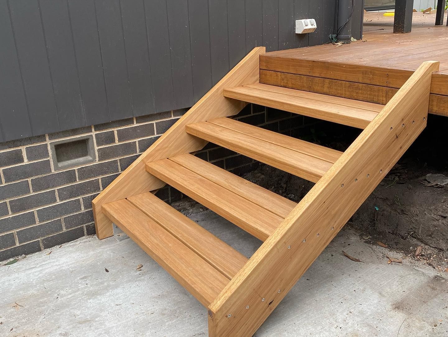 A set of wooden stairs leading up to a deck