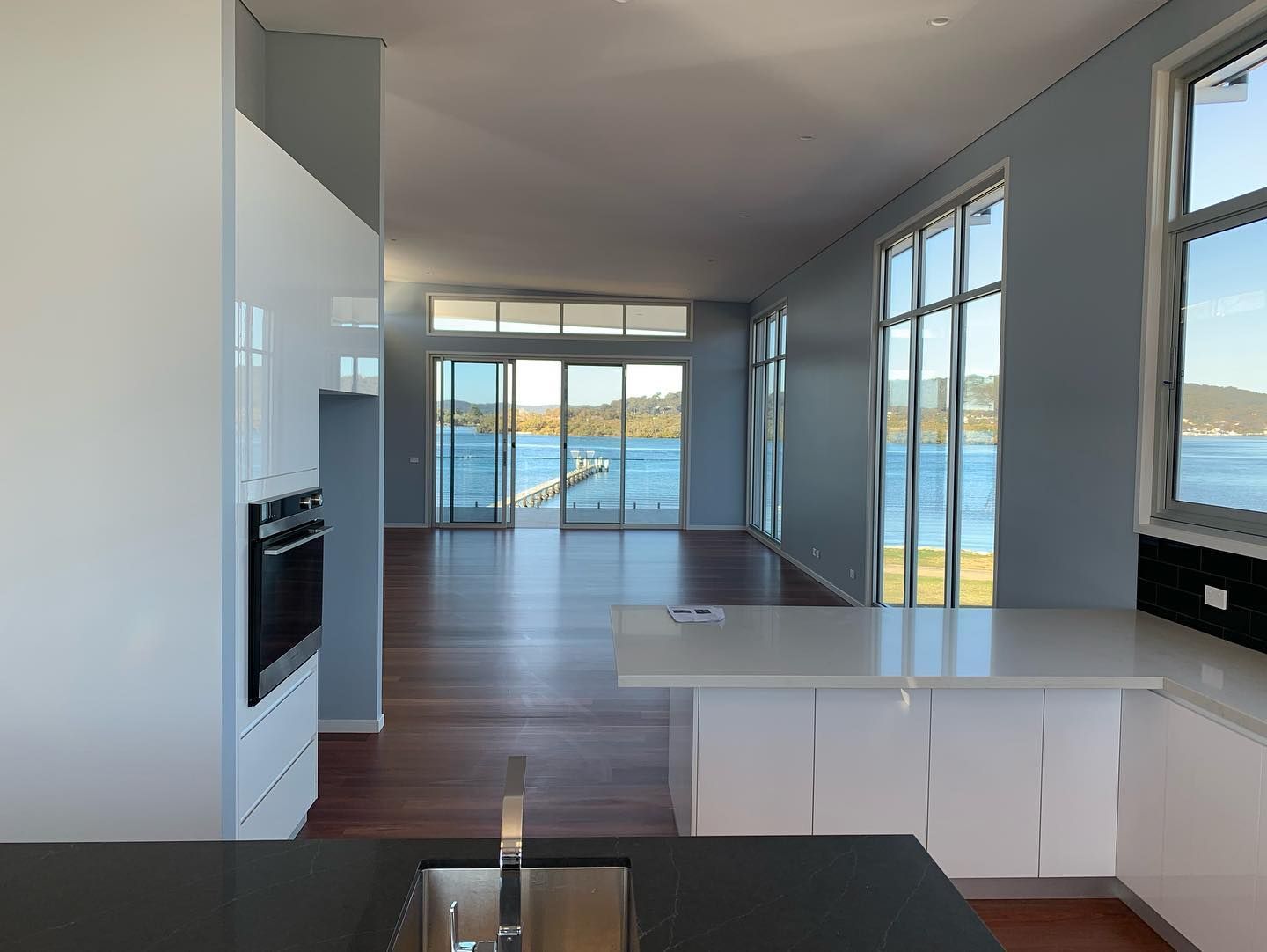 A kitchen with a sink and a view of a body of water