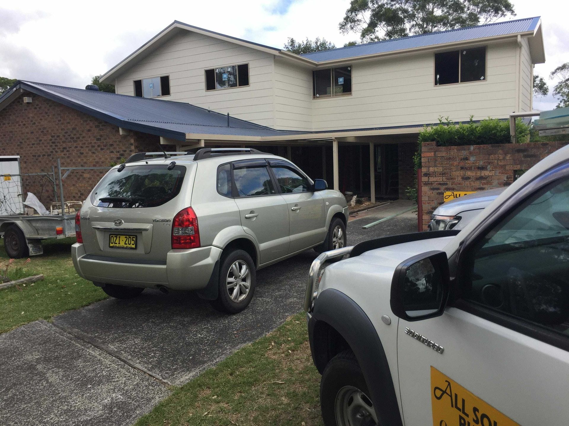 Two cars are parked in front of a house.