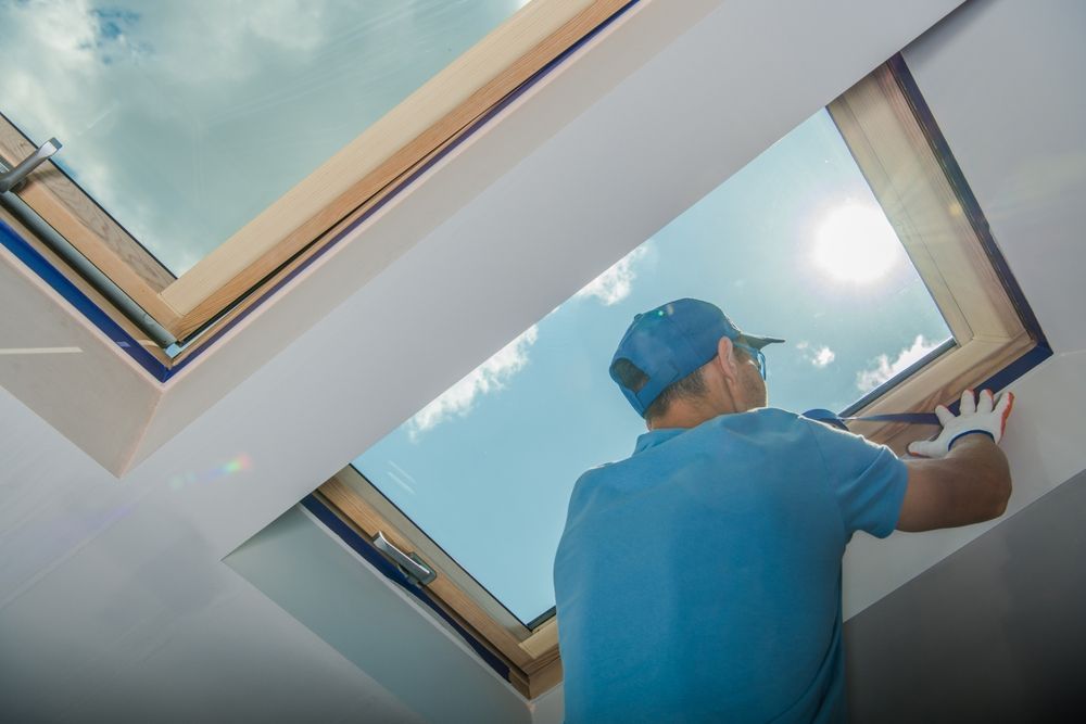A man is installing a skylight in a house.