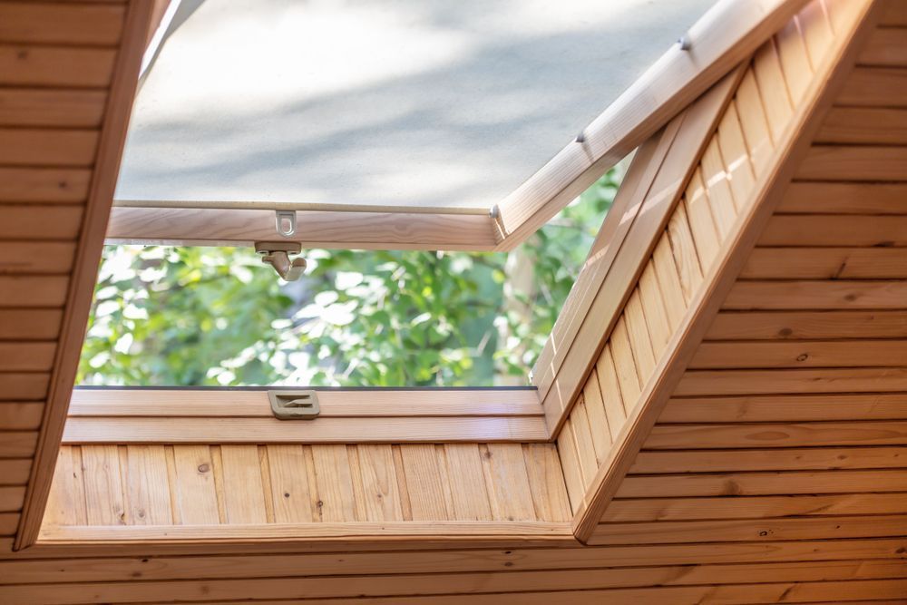 A skylight in a wooden house with a window open.