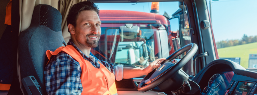 A man is sitting in the driver 's seat of a truck.