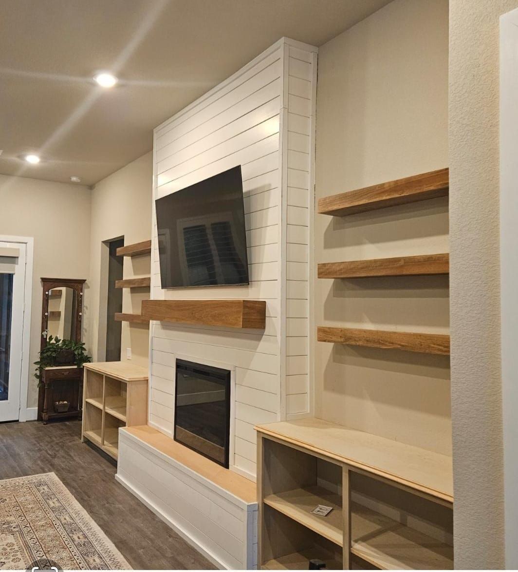 A living room with a fireplace and a flat screen tv