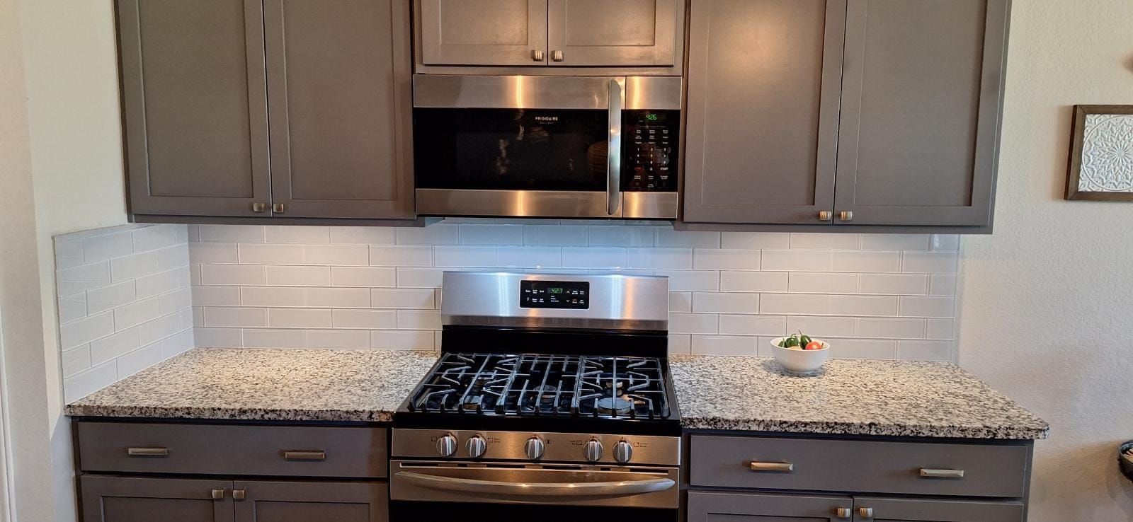 A kitchen with stainless steel appliances and granite counter tops.