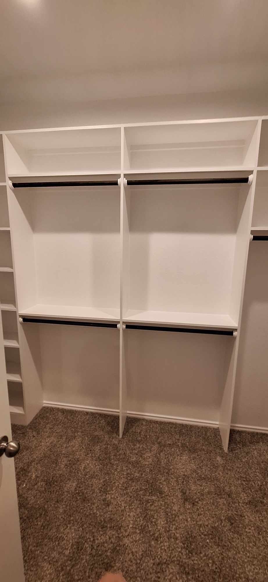 A walk in closet with lots of shelves and clothes racks.
