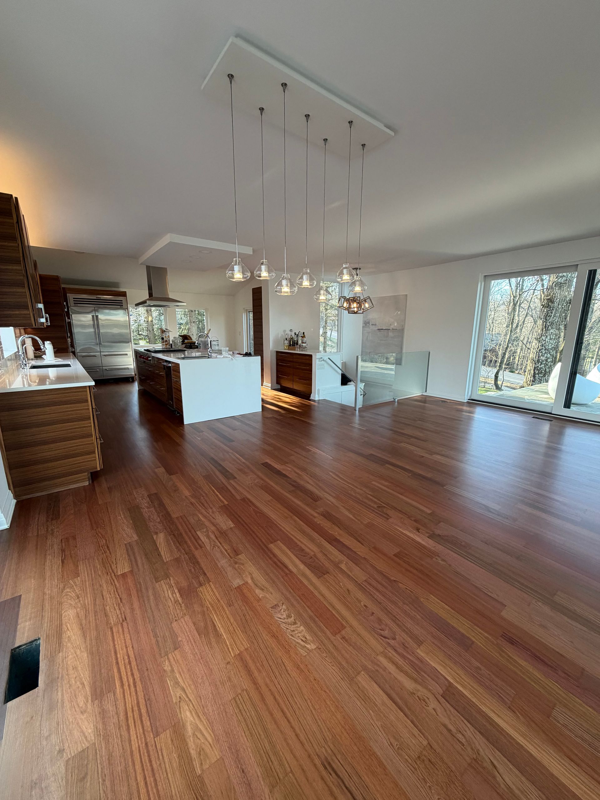 Refinished and restained wide mahogany plank flooring in kitchen dining area