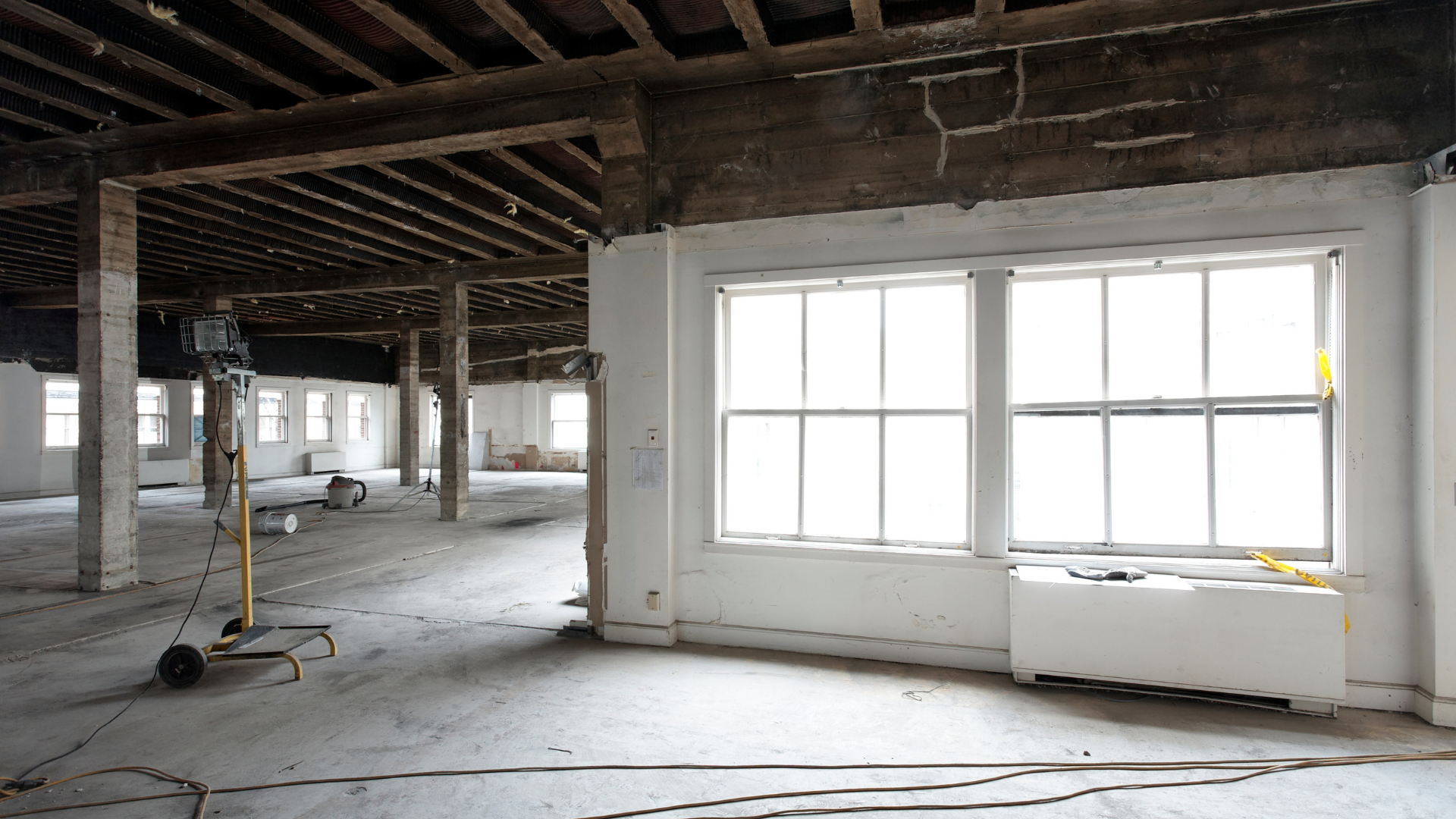 An empty room with a lot of windows and wooden beams