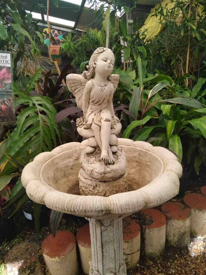 A statue of a fairy sitting on top of a fountain in a garden — Junction Hill Nursery in Junction Hill, NSW