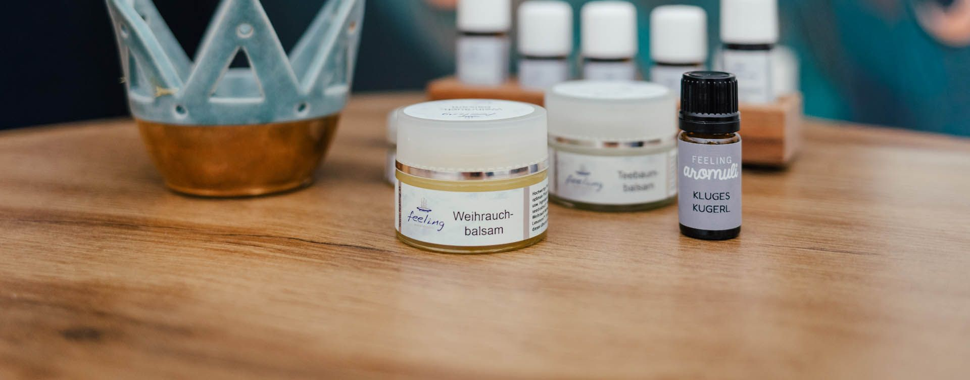Ätherisches Öl auf einem Holztisch. Im Hintergrund befinden sich weitere Tiegel