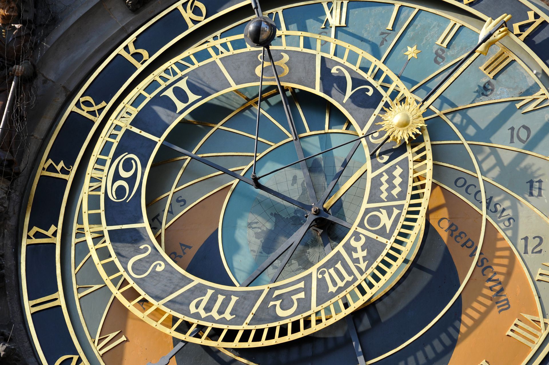 Astronomisches Zifferblatt mit Tierkreiszeichen, Zahlen und Himmelselementen in Gold und Blau.