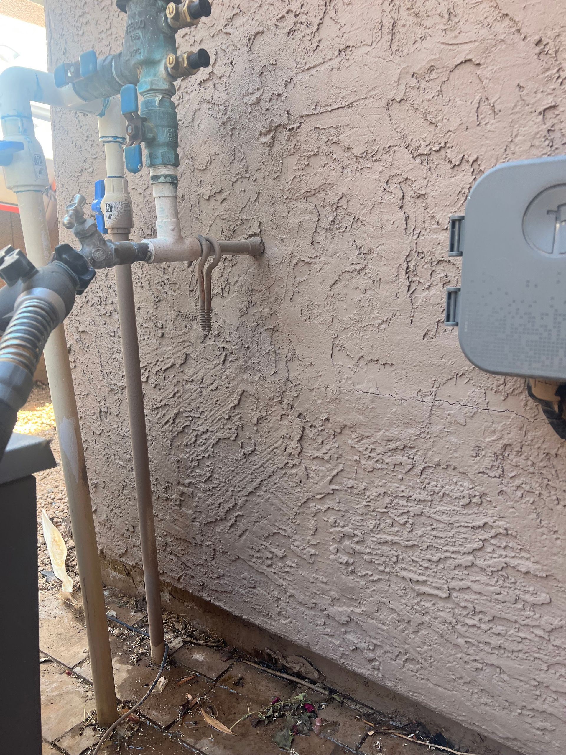 A hose is connected to a faucet on the side of a building.