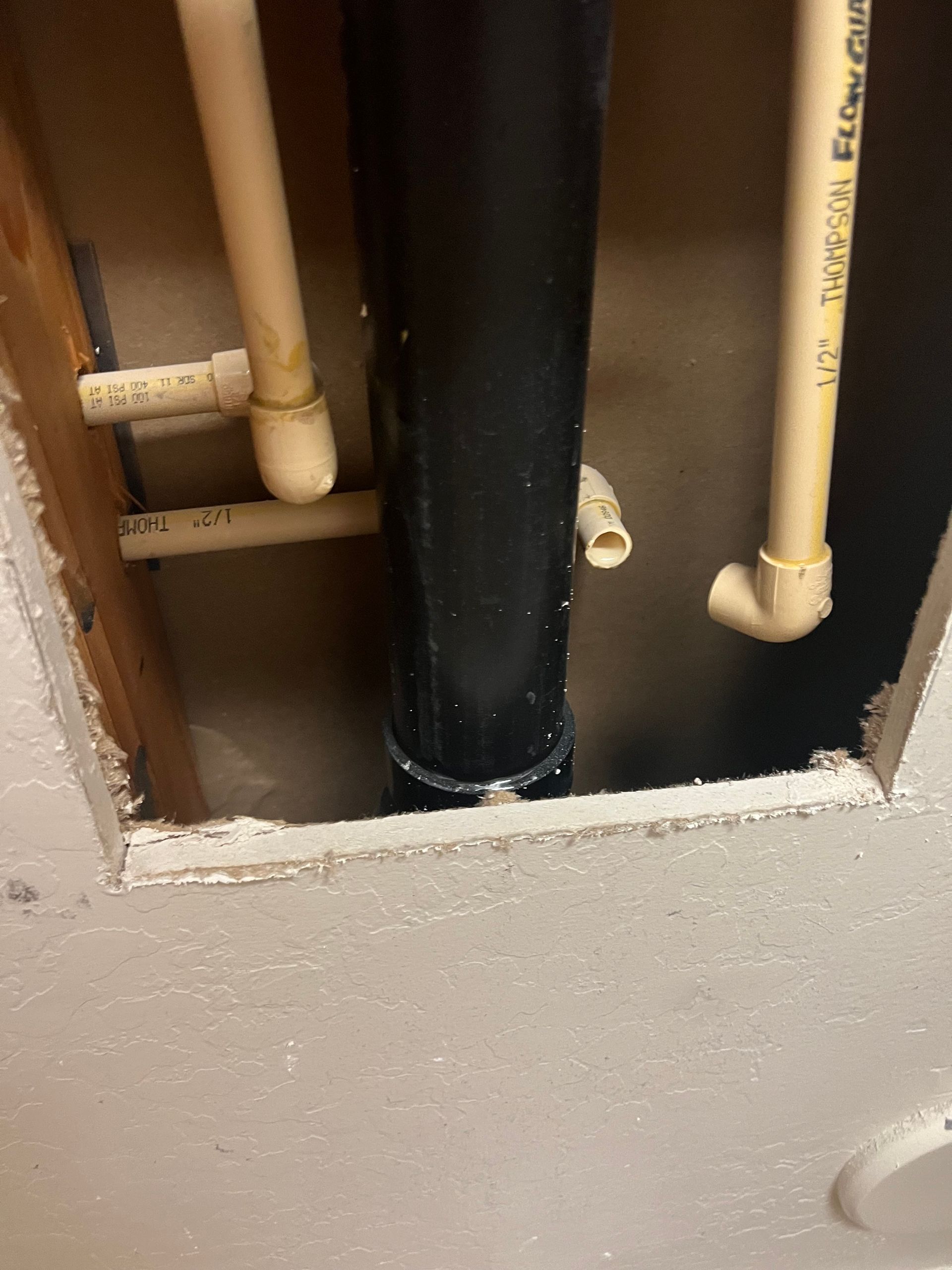 A close up of a pipe in a hole in a wall.