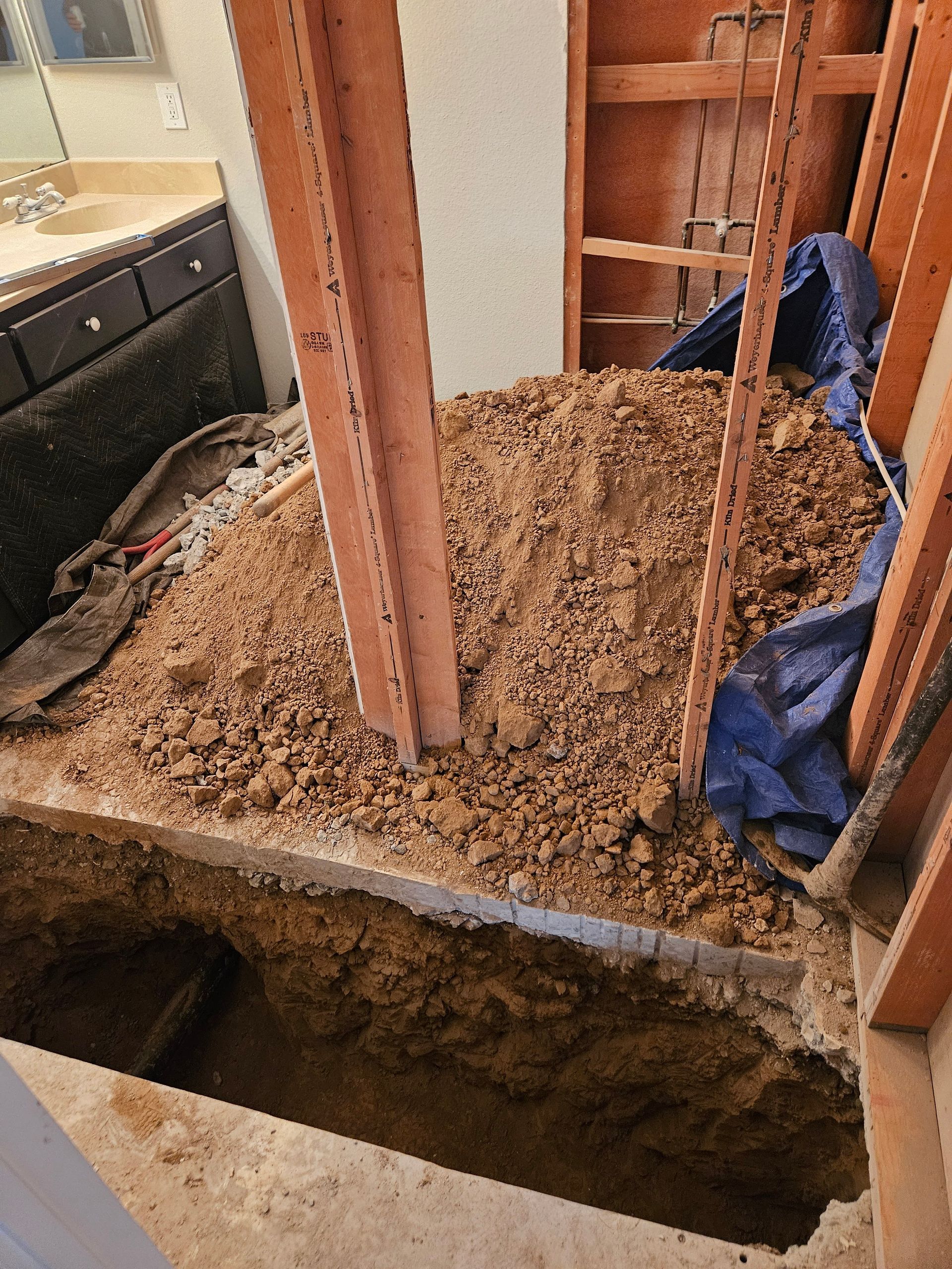 A hole in the ground in a bathroom under construction.