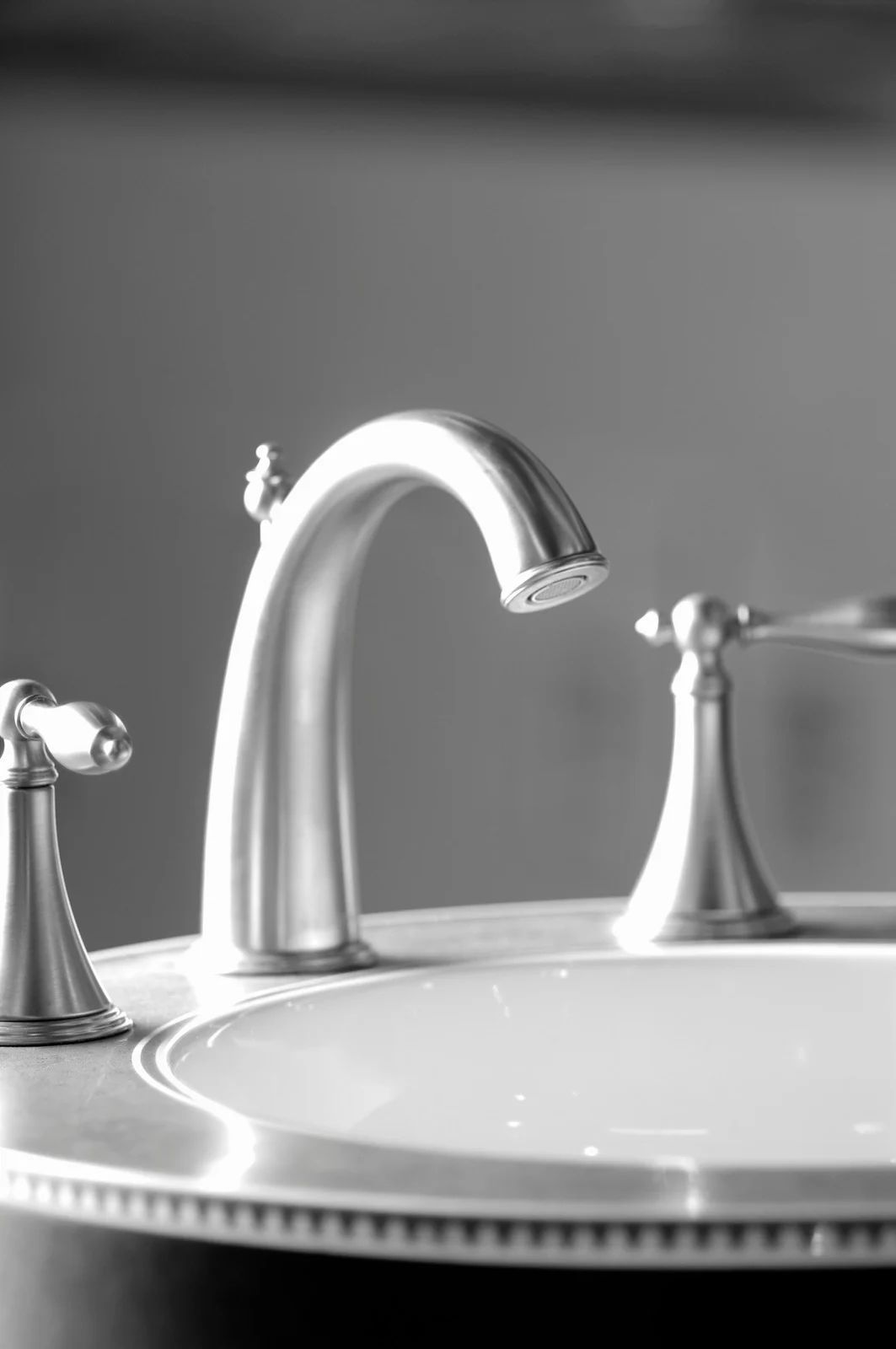 Bathroom sink with brushed silver faucet and handles.