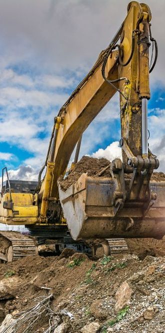 A Yellow Excavator is Loading Dirt Into a Bucket on a Construction Site — Copp & Co Civil & Plant Hire in Proserpine, QLD